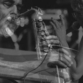 Composite black and white photograph of person playing saxophone and person singing